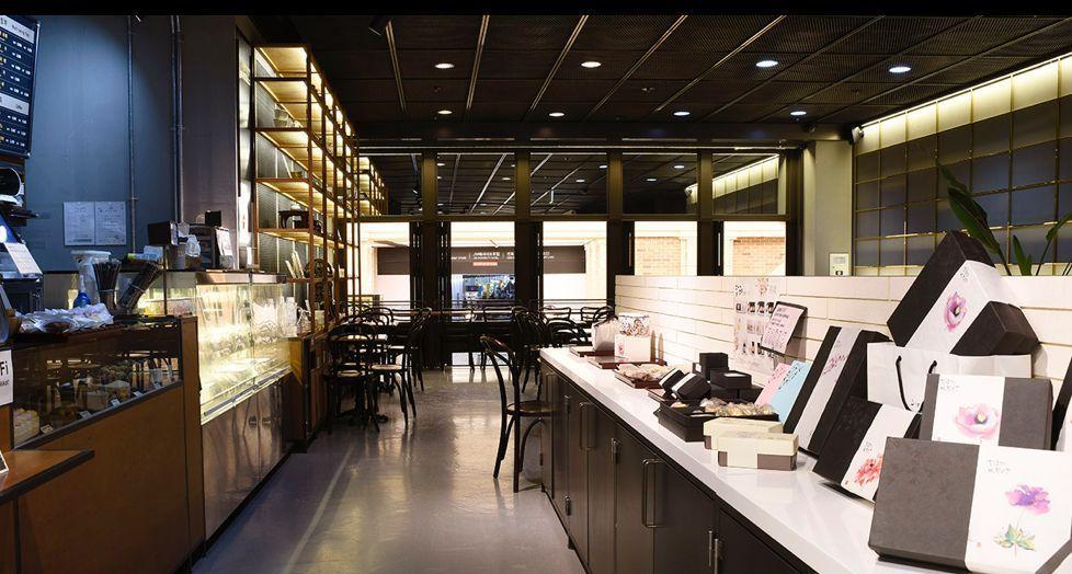 位于高速巴士站的篱笆边的菊花咖啡厅，店内陈列着多样的糕点礼盒与饮料，氛围温馨吸引人。